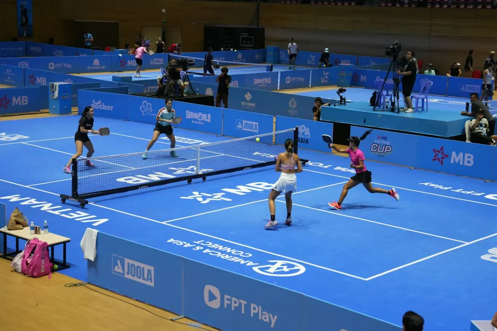 Joueurs de pickleball souriants sur un terrain en extérieur